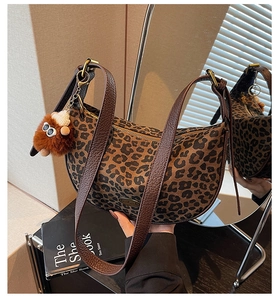 Detail der hobo-tasche mit leopard-muster lederriemen und süßem plüsch-anhänger