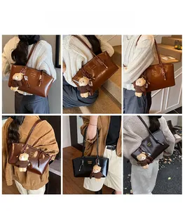 Detail view of stylish leather tote bags in brown and black with bear charms