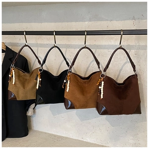 Close-up of vintage matte suede tote bags in four colors with ethnic beaded pendant details