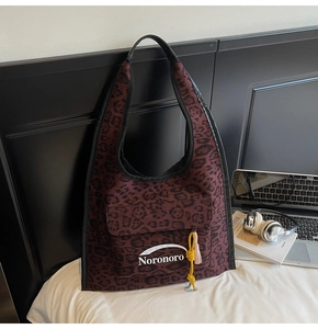 Détail du sac hobo avec imprimé léopard rouge en toile et poche à logo unique