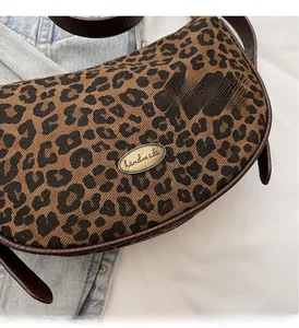 Nahaufnahme der Leopardenmuster-Tasche mit Handmade-Metallplakette und Lederbesatz