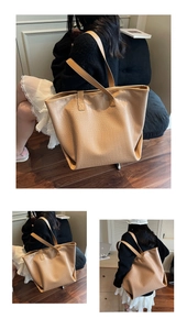 Macro detail of large camel tote bag with crocodile pattern and dual shoulder straps