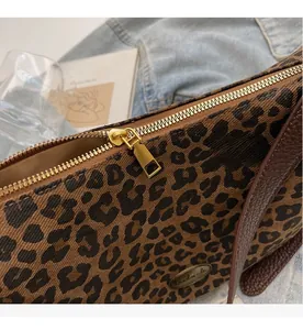 Detail der Canvas-Tasche mit Leopardenmuster, goldenem Reißverschluss und Lederriemen