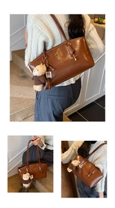 Detail of brown glossy leather tote bag featuring gold lettering and cute bear charm