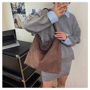 Dettaglio di una grande borsa hobo in pelle scamosciata marrone dalla trama morbida