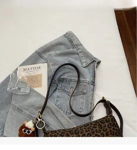 Detailansicht der Schultertasche mit Leopardenmuster und kleinem Bärenanhänger