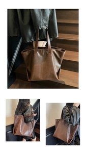 Detailed view of brown crocodile embossed tote bag texture with long shoulder straps