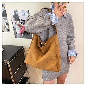 Vista dettagliata di una borsa hobo in pelle scamosciata marrone con design morbido e minimale