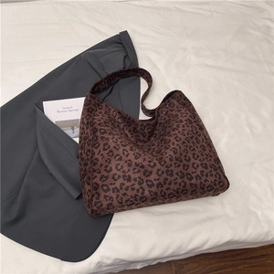 Dettaglio della trama in tessuto leopardato della borsa tote in tela su sfondo bianco
