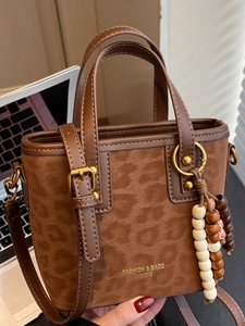 Retro leopard print crossbody bucket bag with wood bead tassel in a commute office setting