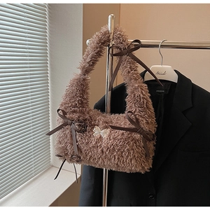 Dettagli della consistenza marrone peluche e dei fiocchi in pelle sulla borsa a spalla