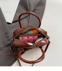 Top view showing the spacious interior of the brown pillow bag with phone and wallet