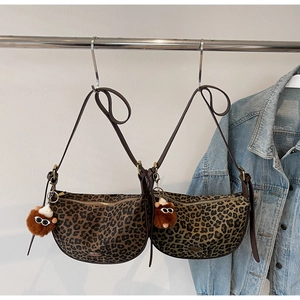 Detail von Taschen mit Leopardenmuster, Goldreißverschluss und Plüschanhänger