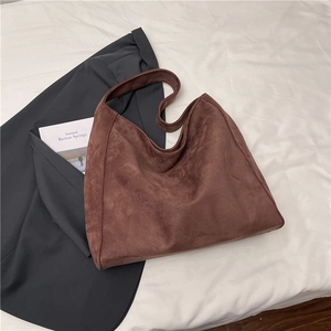 Dettaglio della borsa tote in pelle scamosciata marrone con capienza e texture morbida