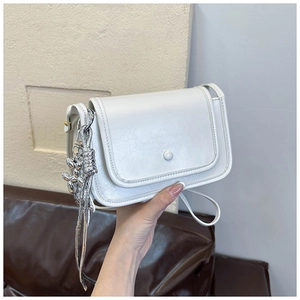 Dettaglio della borsa squadrata bianca con catena in metallo argento e sfere decorative
