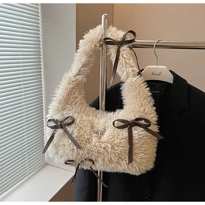 Dettaglio borsa a tracolla in peluche con fiocchi decorativi in pelle marrone sul manico