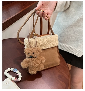 Detail of vintage suede crossbody bag with fleece patchwork and a plush bear charm