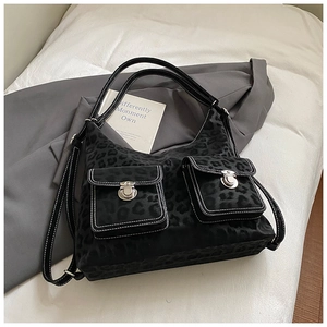 Detail of leopard print tote bag featuring contrast stitching and silver metal locks