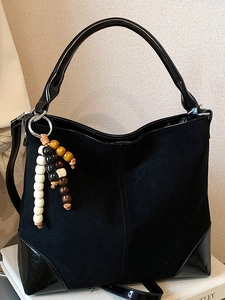 Retro black matte suede shoulder bag with polished trim and colorful beaded charm