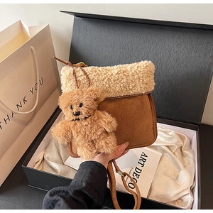 Brown suede crossbody bag with fleece trim and bear charm in premium gift box packaging