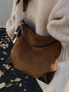 Vintage brown suede hobo bag for women with decorative wood beads in autumn setting
