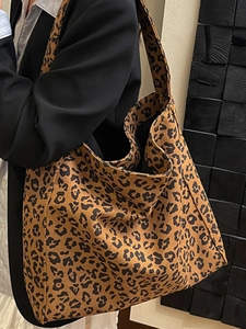 Grande borsa tote in tela con stampa leopardata e spalline larghe indossata