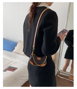 Détails du sac hobo avec surpiqûres contrastées et chaîne dorée décorative