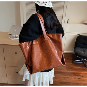 Brown crocodile embossed tote bag shown on shoulder for daily large capacity style