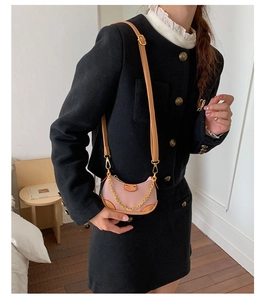 Détail du mini sac croissant rose avec chaîne dorée et finitions en cuir marron chic