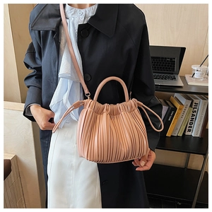 Detail of pink pleated bucket bag with top handle and adjustable strap for women