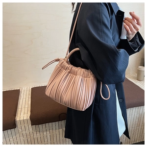 Detailed shot of pink pleated cloud bucket bag with soft PU leather and top handle
