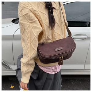 Dettaglio della borsa Boston in camoscio marrone con doppia cerniera e logo del brand LITTU