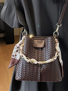 Elegant dark brown woven bucket bag with gold chain strap and silk scarf decoration