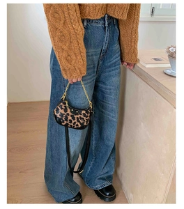 Détail du mini sac à main léopard avec chaîne dorée sur un pull en maille