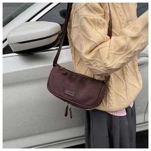 Borsa Boston in pelle scamosciata marrone con dettagli dorati e nappine in pelle sulla foto