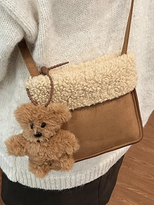 Brown frosted leather crossbody bag with cream fleece trim and a cute plush bear charm