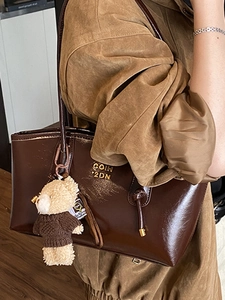 Glossy dark brown tote bag with vintage gold lettering and cute bear charm detail