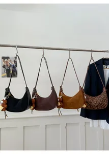 Multiple stylish leopard and suede hobo bags hanging with cute plush bear charms