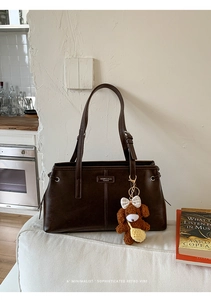 Deep brown retro tote bag with smooth leather finish and cute plush puppy charm detail