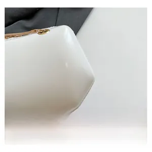 Close-up of white PU leather texture with high-quality gold hardware on a mini evening bag