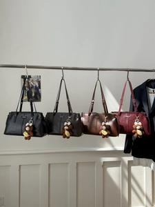 Detail view of glossy PU leather handbags in four colors with cute plush bear charms