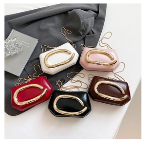 Detail of mini metallic chain bags in five colors with oversized gold C-shaped buckles