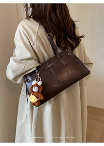 Detail view of dark coffee vintage PU leather tote bag with a cute brown plush bear charm