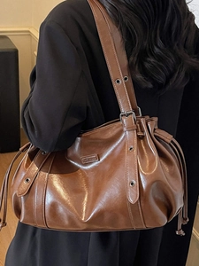 Brown vintage hobo shoulder bag with glossy finish and drawstring closure for women