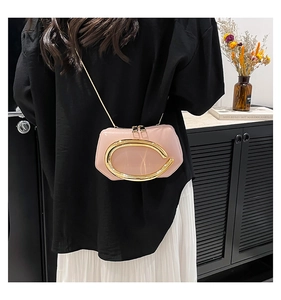 Close-up of pink patent leather mini crossbody bag with gold metal hardware and chain strap