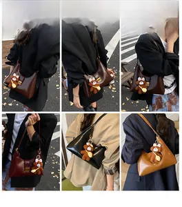 Detailed street style look of the vintage glossy leather half-moon underarm bag with teddy charm