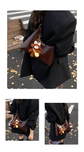 Detail of dark brown faux leather hobo bag with cute plush bear pendant accessory