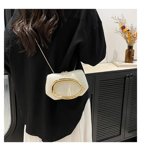 Detailed view of white clouds shaped evening bag with large golden metal handle