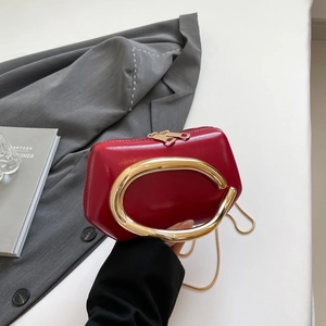 Detailed macro view of the mini red matte bag with its signature oval gold metal handle