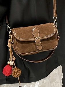 Retro brown suede crossbody bag with vintage metal buckle and decorative pom-pom charm